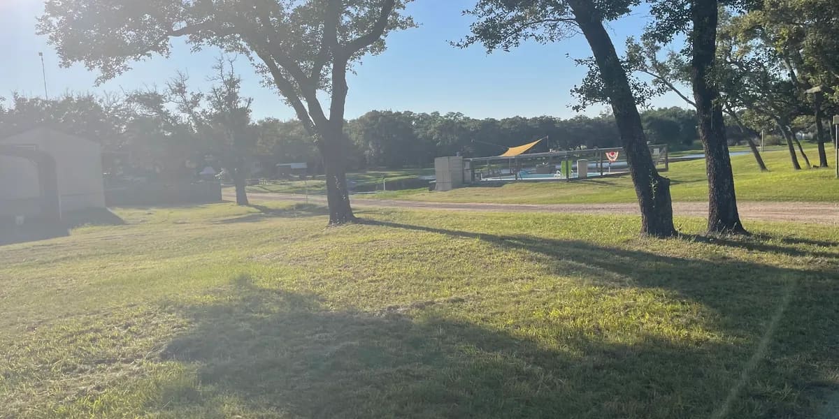 Oak-shaded grounds and pool area at New Season RV Resort, Aransas Pass TX